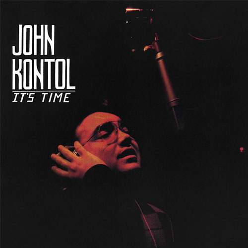 A person wearing glasses sings into a microphone in a dimly lit setting. Text reads "It's Time by John Kontol.